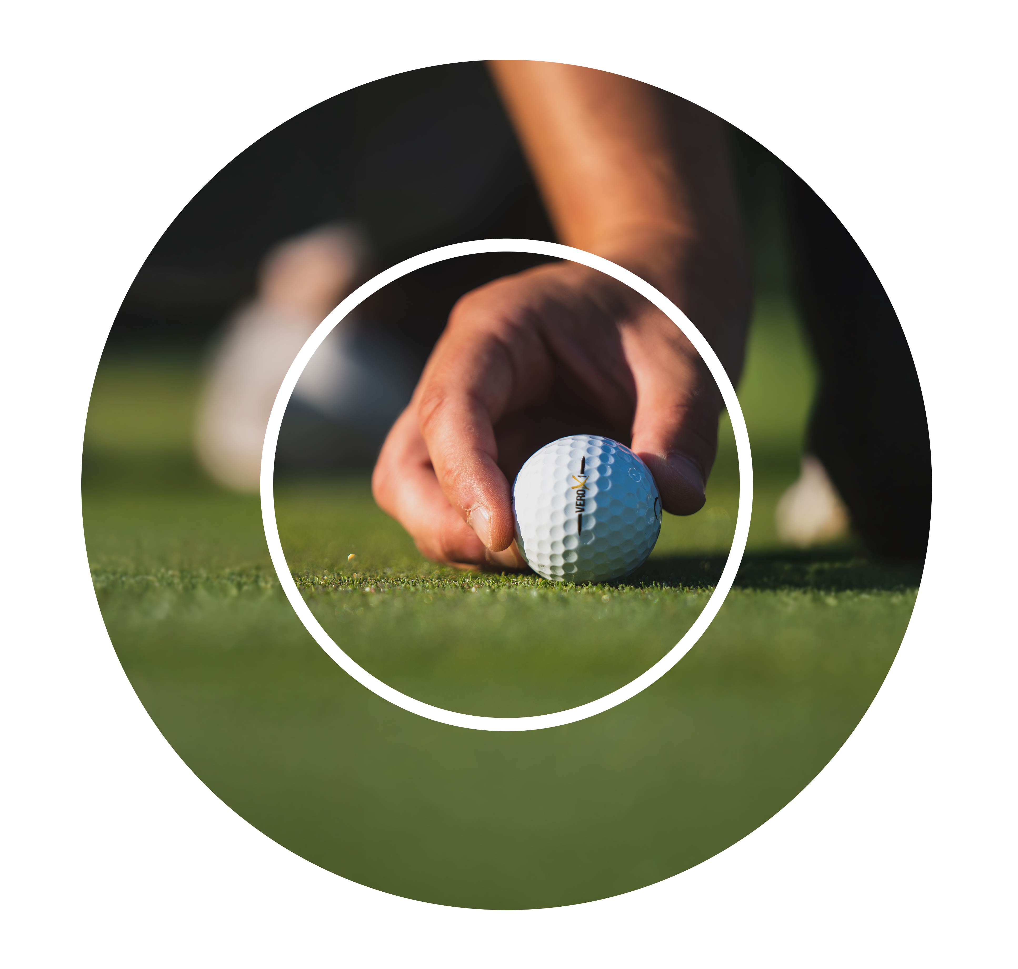 Close-up of a hand placing a golf ball on manicured green grass. The focus is on the ball and hand, creating a calm, focused atmosphere.